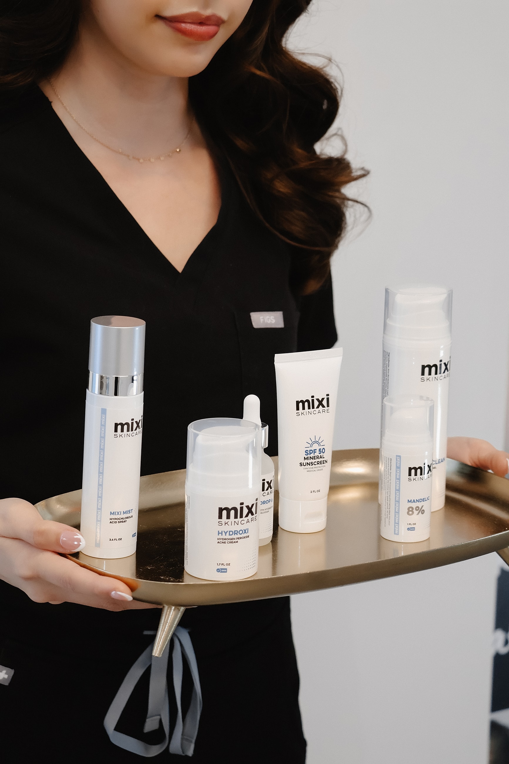 Skincare products displayed on a golden tray.